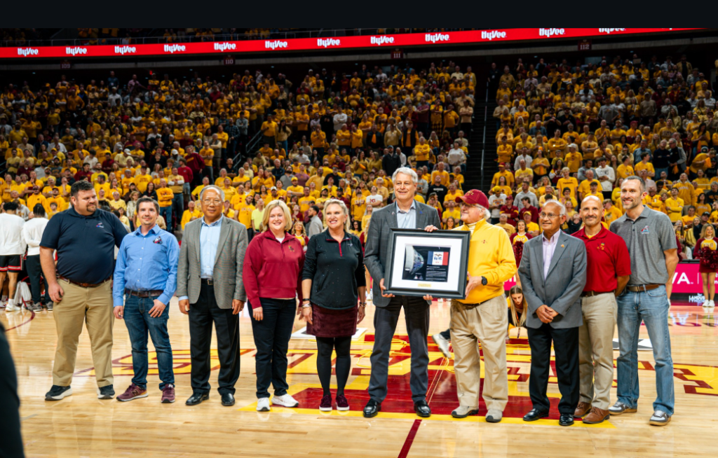 Group of people standing on the floor of the Iowa State arena